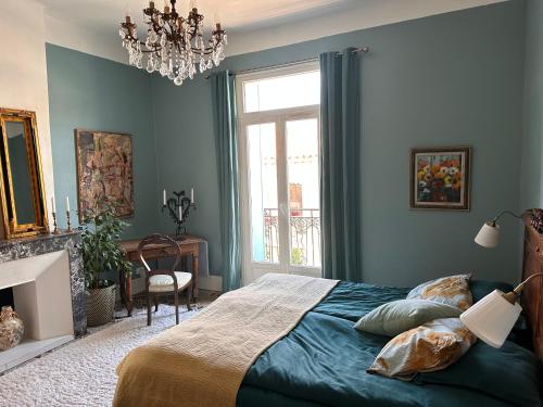 une chambre bleue avec un lit et une fenêtre dans l'établissement Chic Béziers Town House, à Béziers