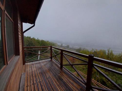 a balcony of a house with a view of a foggy field at The River View Villa الحلال Halal Concept in Quba