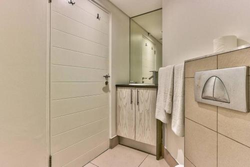 a bathroom with a shower and a sink and a mirror at The Rockwell Apt in DeWaterkant next to Waterfront in Cape Town