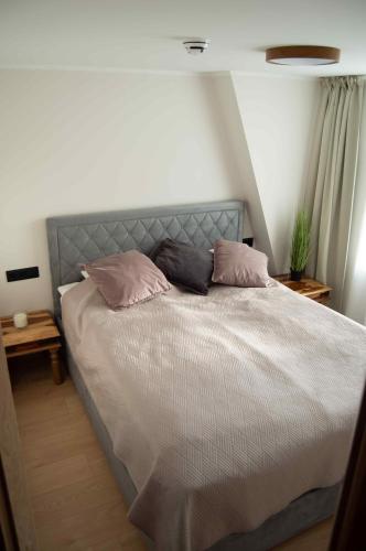 a bedroom with a bed with two pillows on it at Suur-Posti Apartments in Pärnu