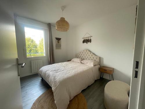 a small bedroom with a bed and a window at sublime appartement in Niort