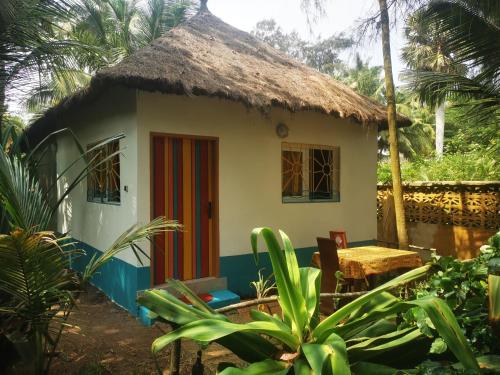 a small house with a thatch roof at Bungalow accés direct plage privée "Plage tropicale Chez Jack et Régine" in Grand-Bassam