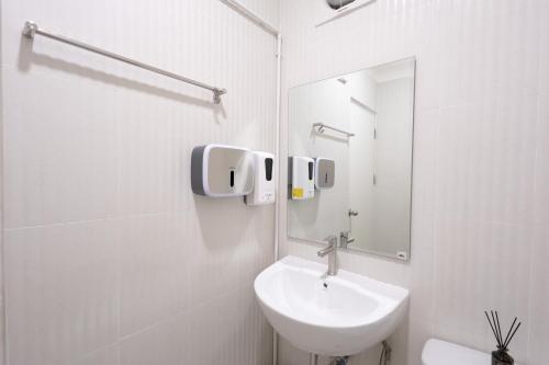 a white bathroom with a sink and a mirror at Cozy & Affordable apartment in Chiang Mai in Chiang Mai