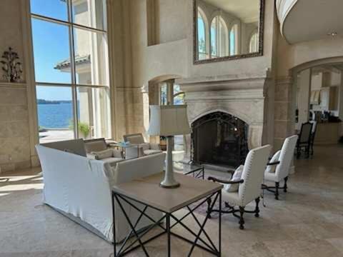 a living room with a fireplace and white chairs at Lakeside Grande Villa in Alexander City