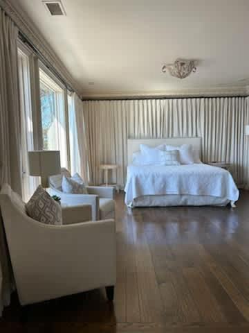 a bedroom with a white bed and a chair at Lakeside Grande Villa in Alexander City