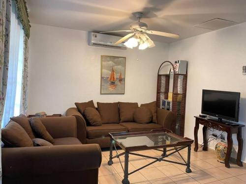 a living room with a couch and a tv at casa de playa dentro del Complejo Turistico Palma Real in El Corazón