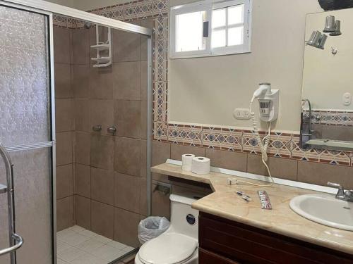 a bathroom with a shower and a toilet and a sink at casa de playa dentro del Complejo Turistico Palma Real in El Corazón