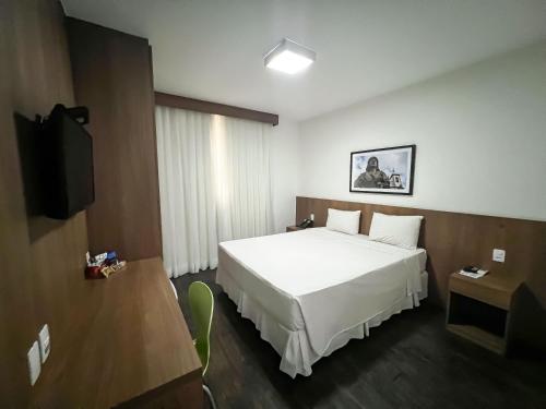 a hotel room with a bed and a television at Nobile Hotel Belo Horizonte in Belo Horizonte
