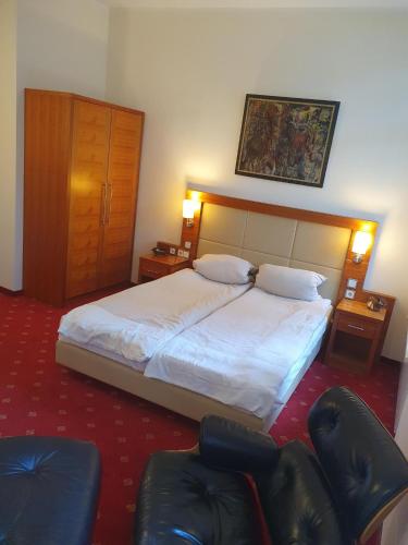 a hotel room with a bed and two chairs at die Villa, Zimmer 24, DZ in Leverkusen