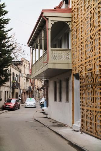 a building with a balcony on the side of a street at Crystal Hotel Tbilisi in Tbilisi City