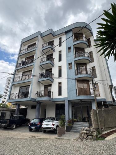 a tall building with cars parked in front of it at Family apartment Prime location and easy access 1 in Addis Ababa