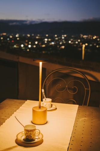 a table with two cups and a lamp on it at Agriturismo Millennial in Quarrata
