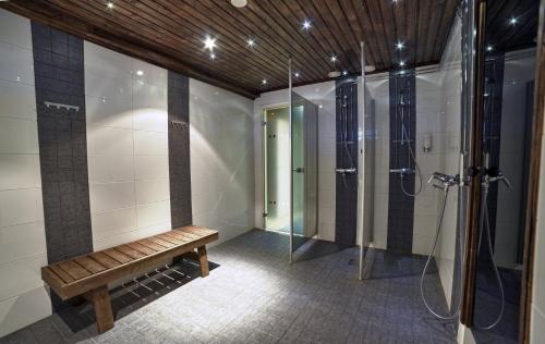 uma cabina de duche ao nível do chão com um banco na casa de banho em Hotel Lapuahovi em Lapua