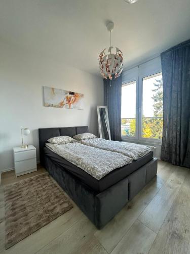 a bedroom with a large bed and a chandelier at Apartament Skarbowa Star in Leszno