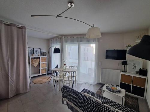 un salon avec un canapé et une table dans l'établissement Ambre Appart-Wifi-Terrasse-Parking-Terrasse-2 couchages, à La Rochelle