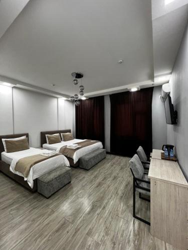 a bedroom with two beds and a couch in it at Shosh Palace in Tashkent