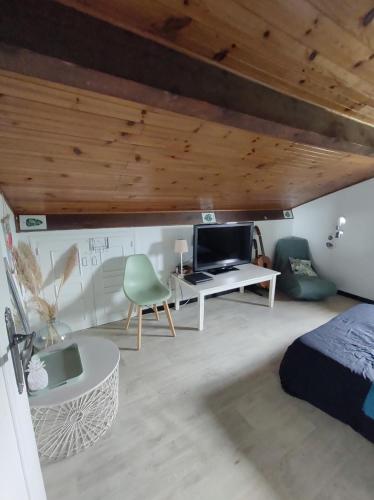 une chambre avec un lit et un bureau avec une télévision dans l'établissement Chambre et salle de bain, à Lescar