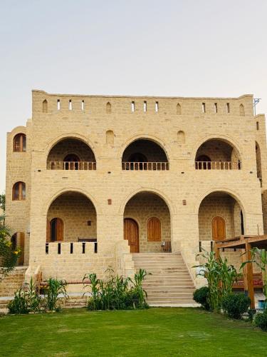 a large brick building with brown doors and stairs at كمبوند قرية تونس in Tunis