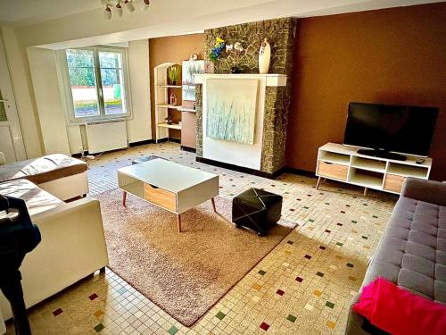 a living room with a couch and a tv at Gîte Le Hamo in Château-Gontier