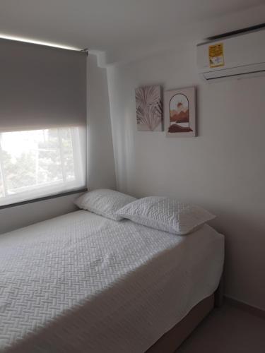 バランキージャにあるApartamento central en Barranquilla para estrenarのベッドと窓のある白い寝室