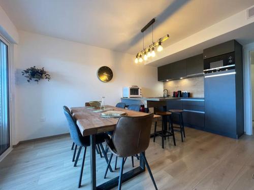 a kitchen and dining room with a table and chairs at L'Escale Paisible, entre dunes et plages in Camiers