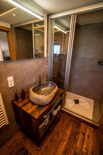a bathroom with a large stone sink on a wooden counter at Tiroler Alpblick Appartements in Ehrwald