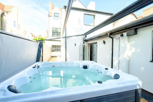 a jacuzzi tub in a room with a window at Curzon Family Home - Pet Friendly - Hot tub - Under New Management in Llandudno