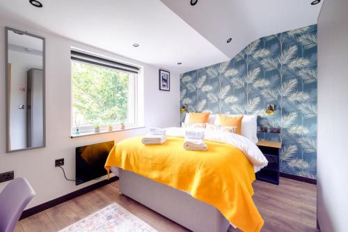 a bedroom with a large yellow bed with a window at Curzon Family Home - Pet Friendly - Hot tub - Under New Management in Llandudno