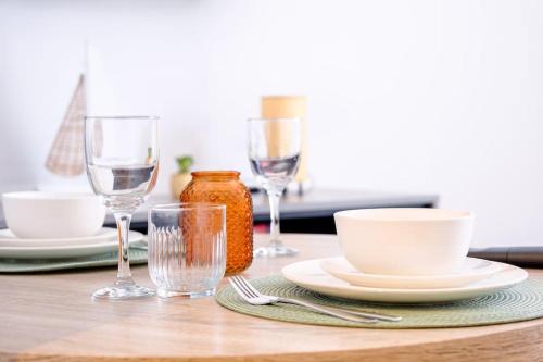 a table with plates and wine glasses on it at Curzon Family Home - Pet Friendly - Hot tub - Under New Management in Llandudno