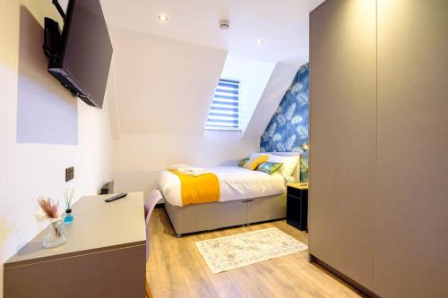 a small bedroom with a bed and a tv at Curzon Family Home - Pet Friendly - Hot tub - Under New Management in Llandudno