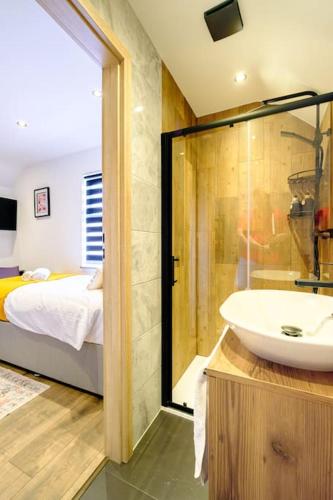 a bathroom with a sink and a bed and a tub at Curzon Family Home - Pet Friendly - Hot tub - Under New Management in Llandudno