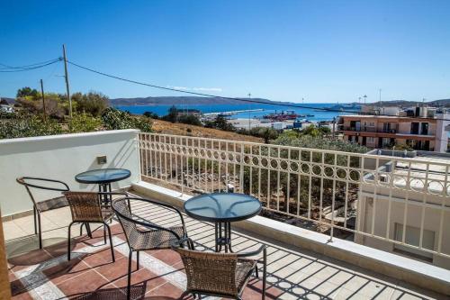 a patio with chairs and tables on a balcony at Portfront Neoclassical Gem in Lavrio in Lávrion