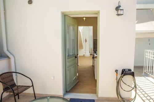 a hallway with a green door and a chair at Portfront Neoclassical Gem in Lavrio in Lávrion