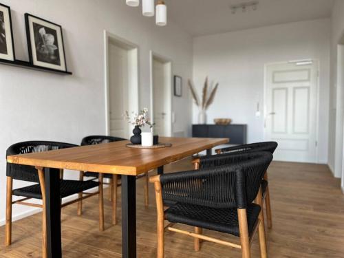 a dining room with a wooden table and chairs at Wohlfühl-Apartment Elbtal in Radebeul