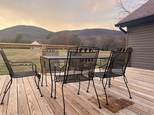 three chairs and a table on a wooden deck at Sycamore Shade in Avon