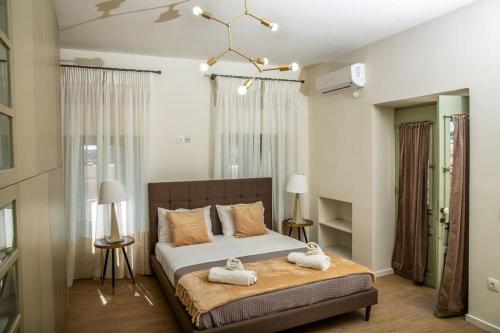 a bedroom with a bed with two towels on it at Portfront Neoclassical Gem in Lavrio in Lávrion