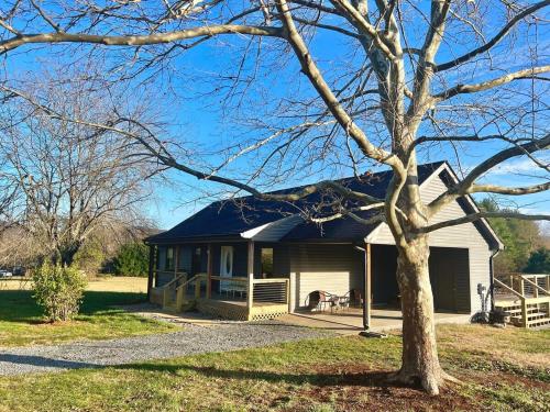 a house with a porch and a tree at Sycamore Shade in Avon