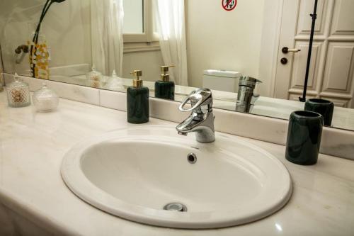 a white sink in a bathroom with a mirror at Portfront Neoclassical Gem in Lavrio in Lávrion