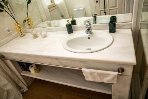 a bathroom counter with a sink and a mirror at Portfront Neoclassical Gem in Lavrio in Lávrion