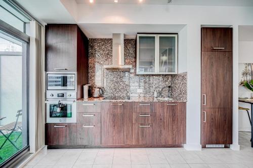 a kitchen with wooden cabinets and a stove at Best Downtown Toronto View! in Toronto