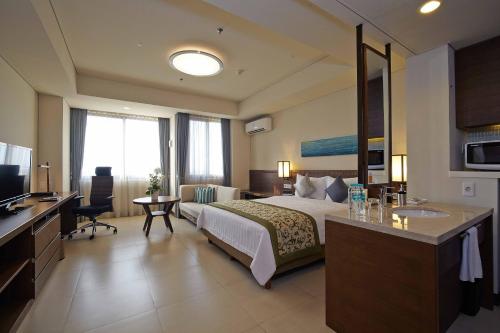 a hotel room with a bed and a desk at Axia South Cikarang Service Apartment in Cikarang