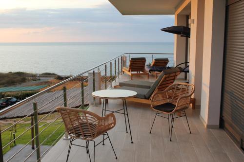 a balcony with chairs and a table and the ocean at Boutique apartments Myesis in Samothráki