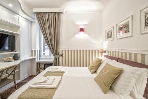 ein Schlafzimmer mit einem weißen Bett und einem Schreibtisch in der Unterkunft La Maison di Sant'Anna in Rom