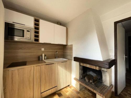 Il dispose d'une cuisine avec une cheminée et un four micro-ondes. dans l'établissement Résidence Sequoias - Charmant appartement avec vue époustouflante MAE-5351, à Vénosc