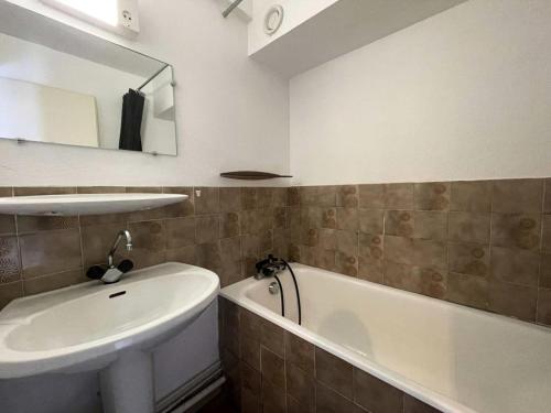 a bathroom with a sink and a tub and a white sink at Résidence Sequoias - Charmant appartement avec vue époustouflante MAE-5351 in Les Deux Alpes
