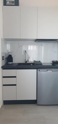 a kitchen with white cabinets and a sink at Boutique apartments Myesis in Samothráki