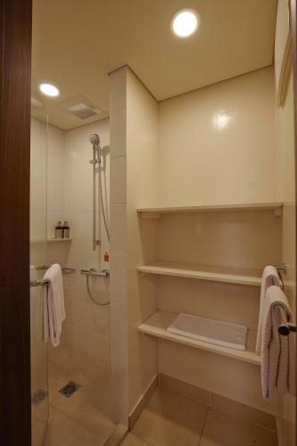 a bathroom with a shower and a walk in shower at Axia South Cikarang Service Apartment in Cikarang