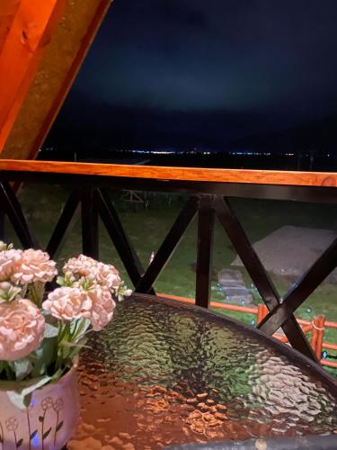 a table with flowers and a bowl of water at CABAÑA PARCELA VISTA HERMOSA in Puerto Aisén