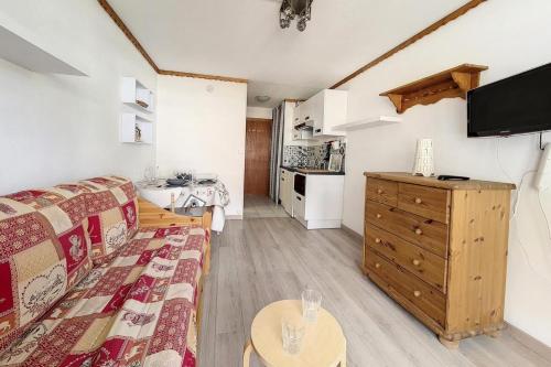 un salon avec un canapé, une table et une télévision dans l'établissement Résidence Oisans - Studio agréable · Skis aux pieds · Balcon MAE-3394, aux Menuires