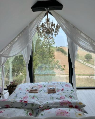 a bedroom with a bed with a chandelier and a window at STODOLA U Františka in Dolní Bojanovice